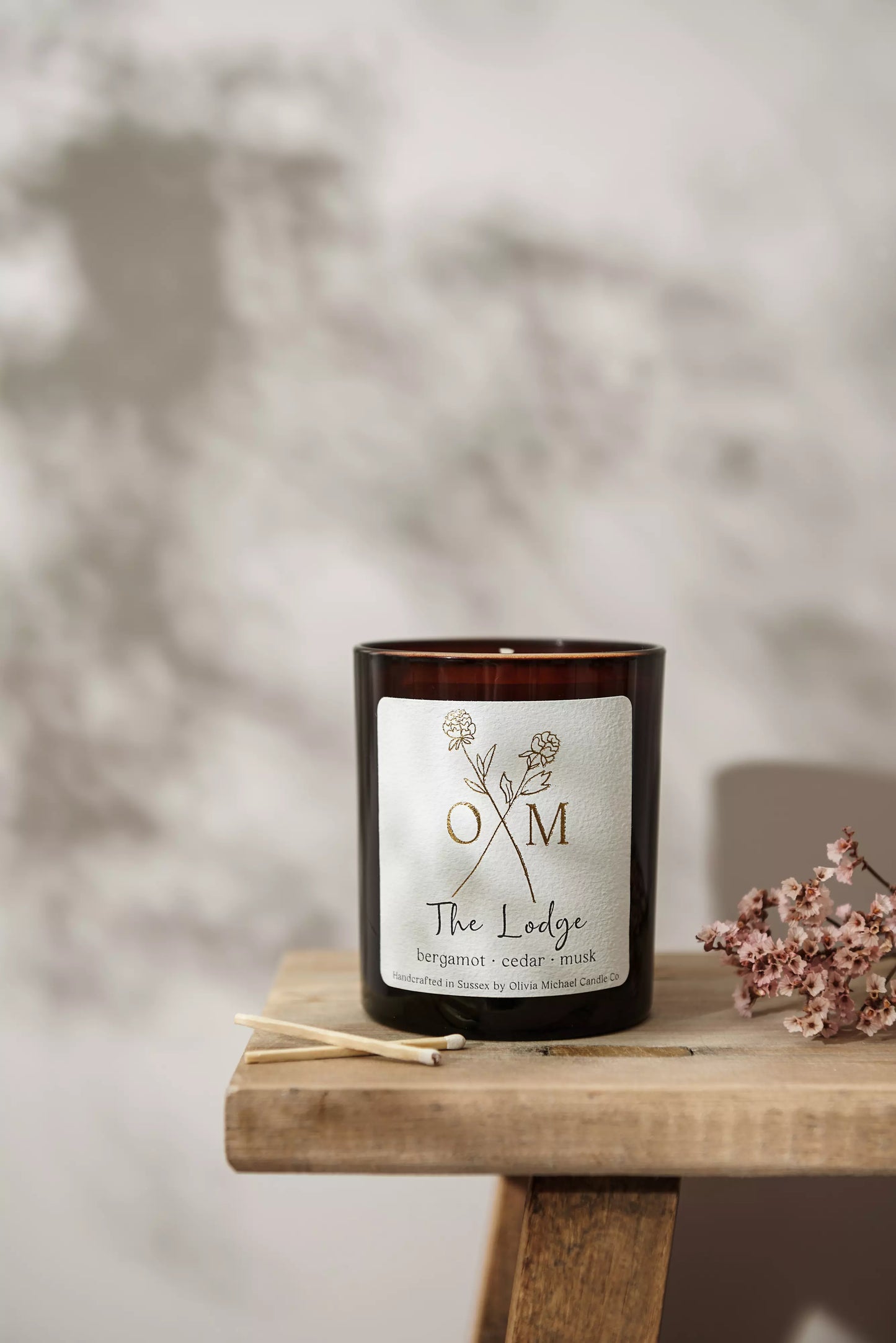 Our bergamot and cedar scented candle is on display in an amber glass jar.