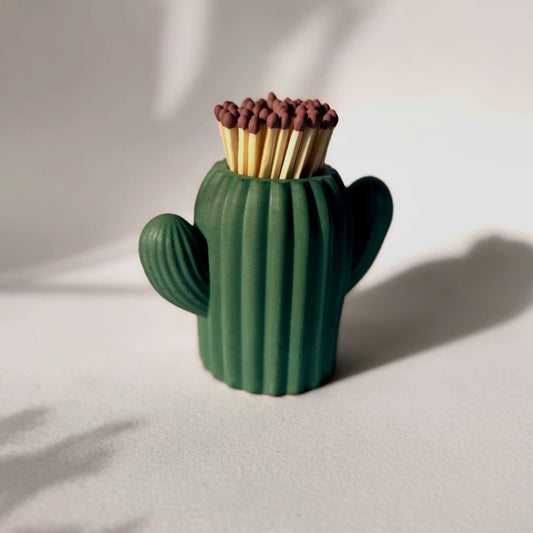 Cactus-shaped matchbox with matches on a light background