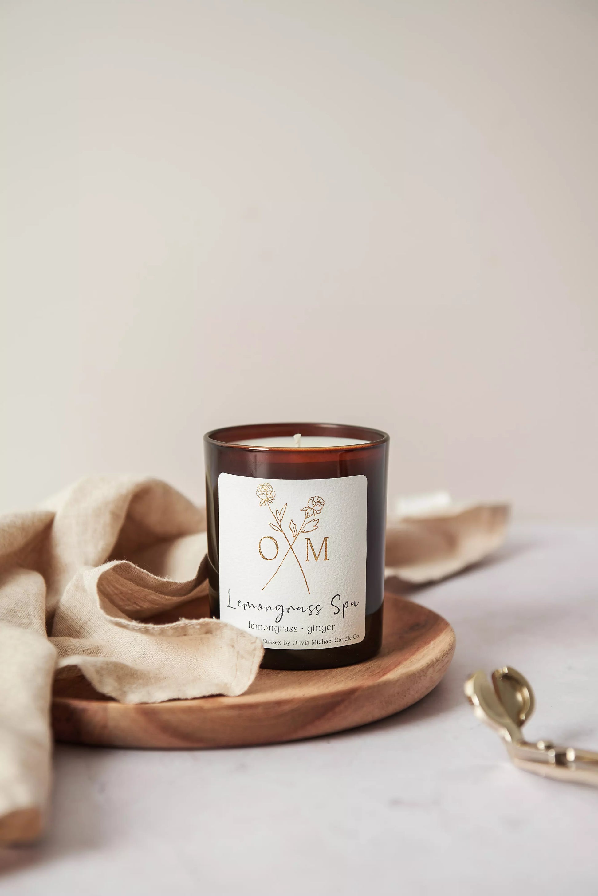 Our lemongrass and ginger scented candle is on display in an amber glass jar.