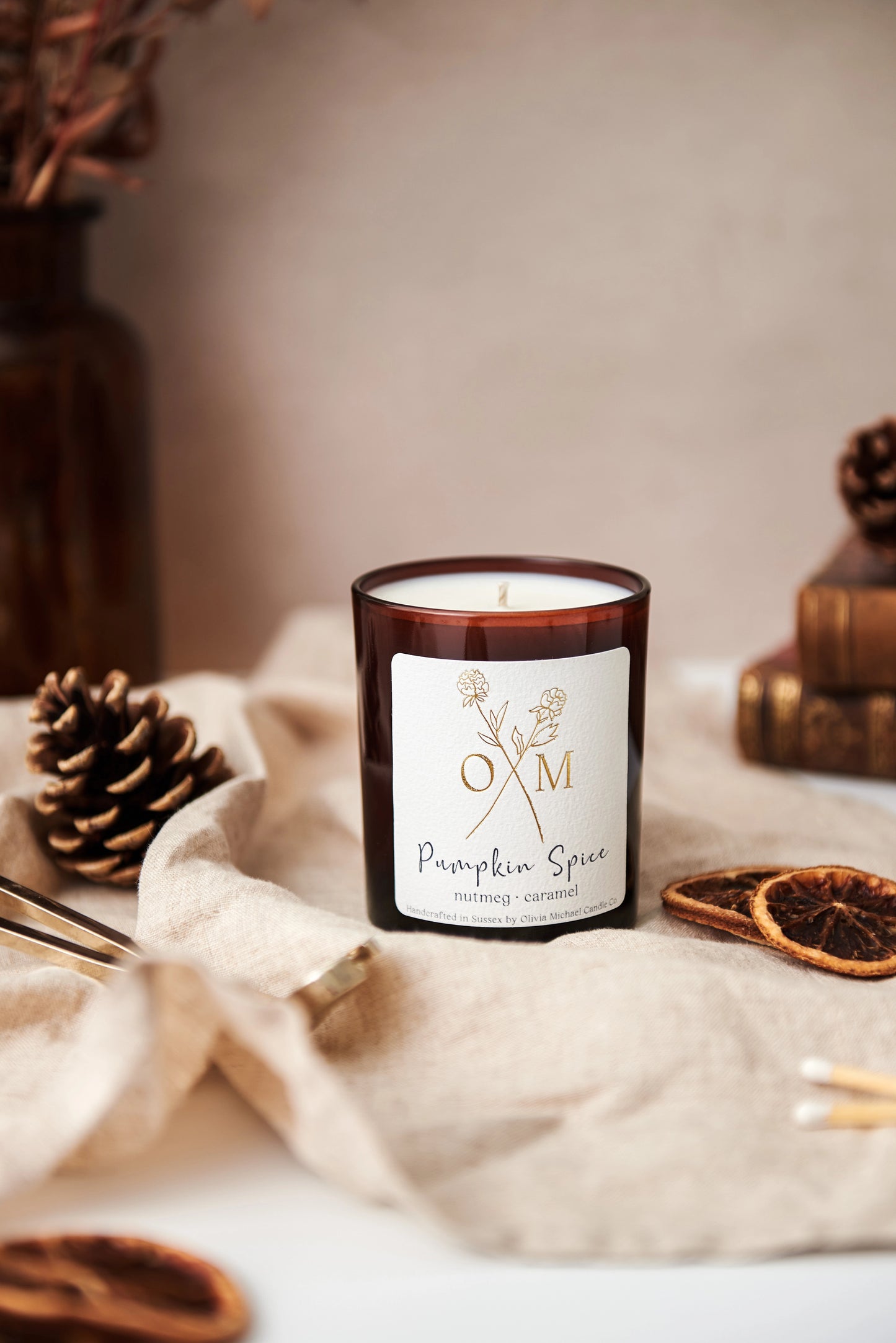 Our autumn scented candle is on display in an amber glass jar.