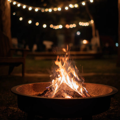 Glowing fire pit under string lights at night, evoking the smoky warmth and rich cedarwood notes of the 'Embers' wax melts.