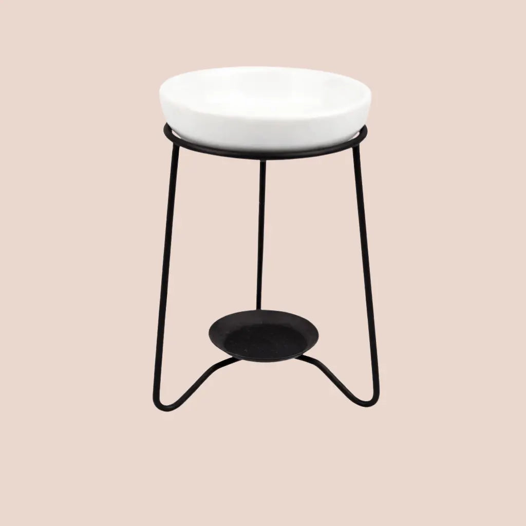 Black metal tea light wax melt burner with a white ceramic dish on top.