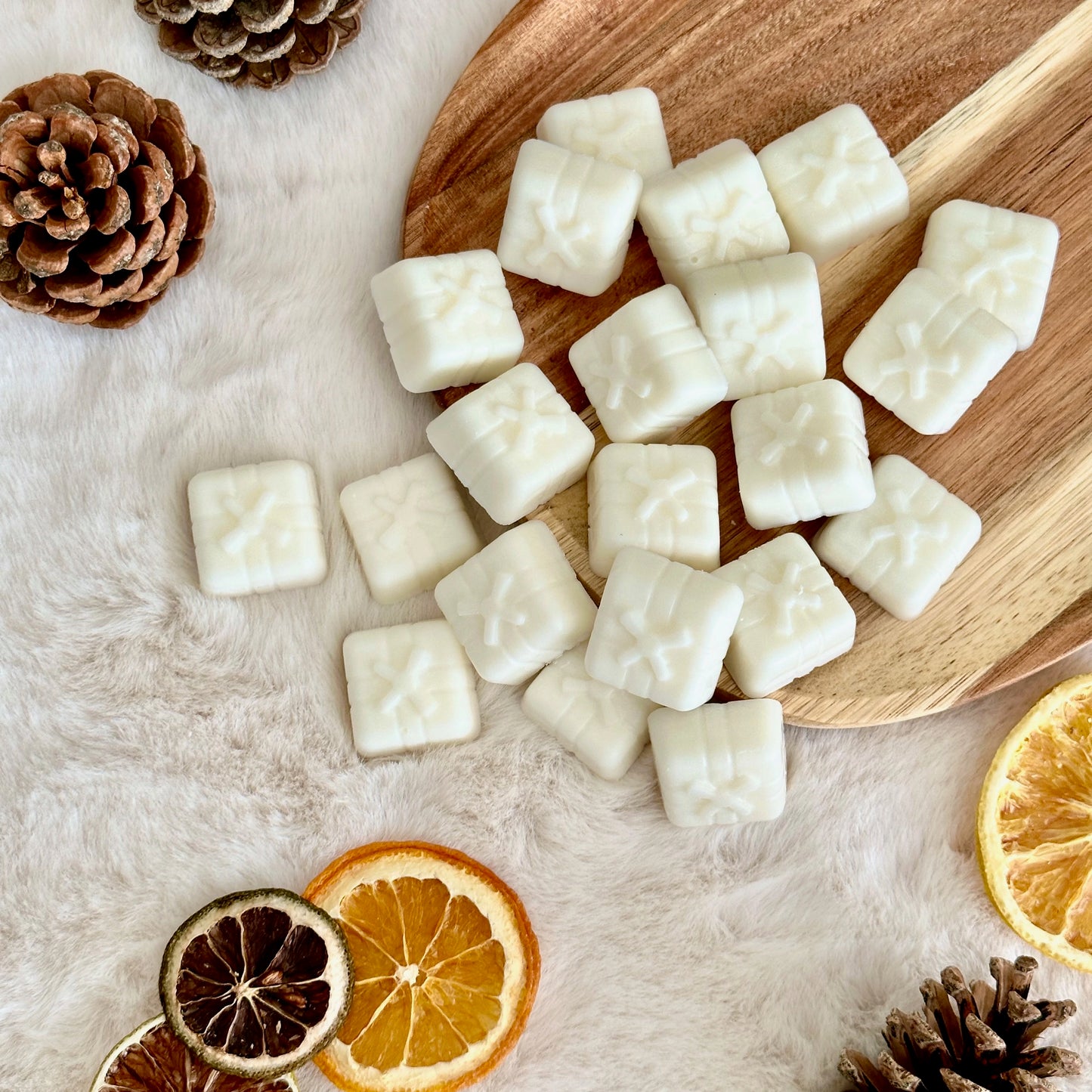 A pile of Winter Berries wax melts on a wooden board.