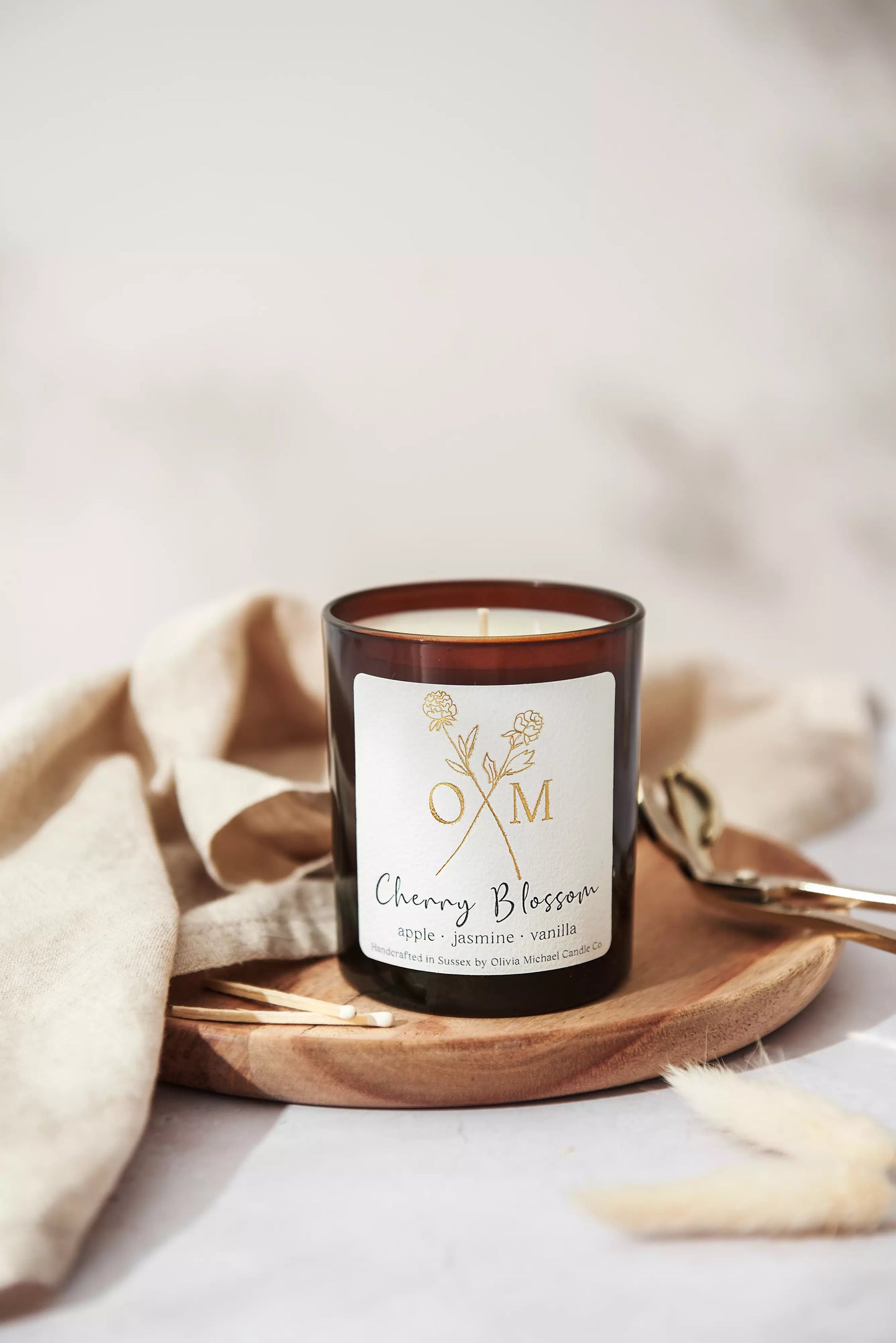 Our apple and vanilla scented candle is on display in an amber glass jar.