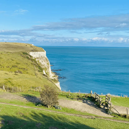 A view over the white cliffs of Beachy Head on a clear day, with the deep blue sea below.