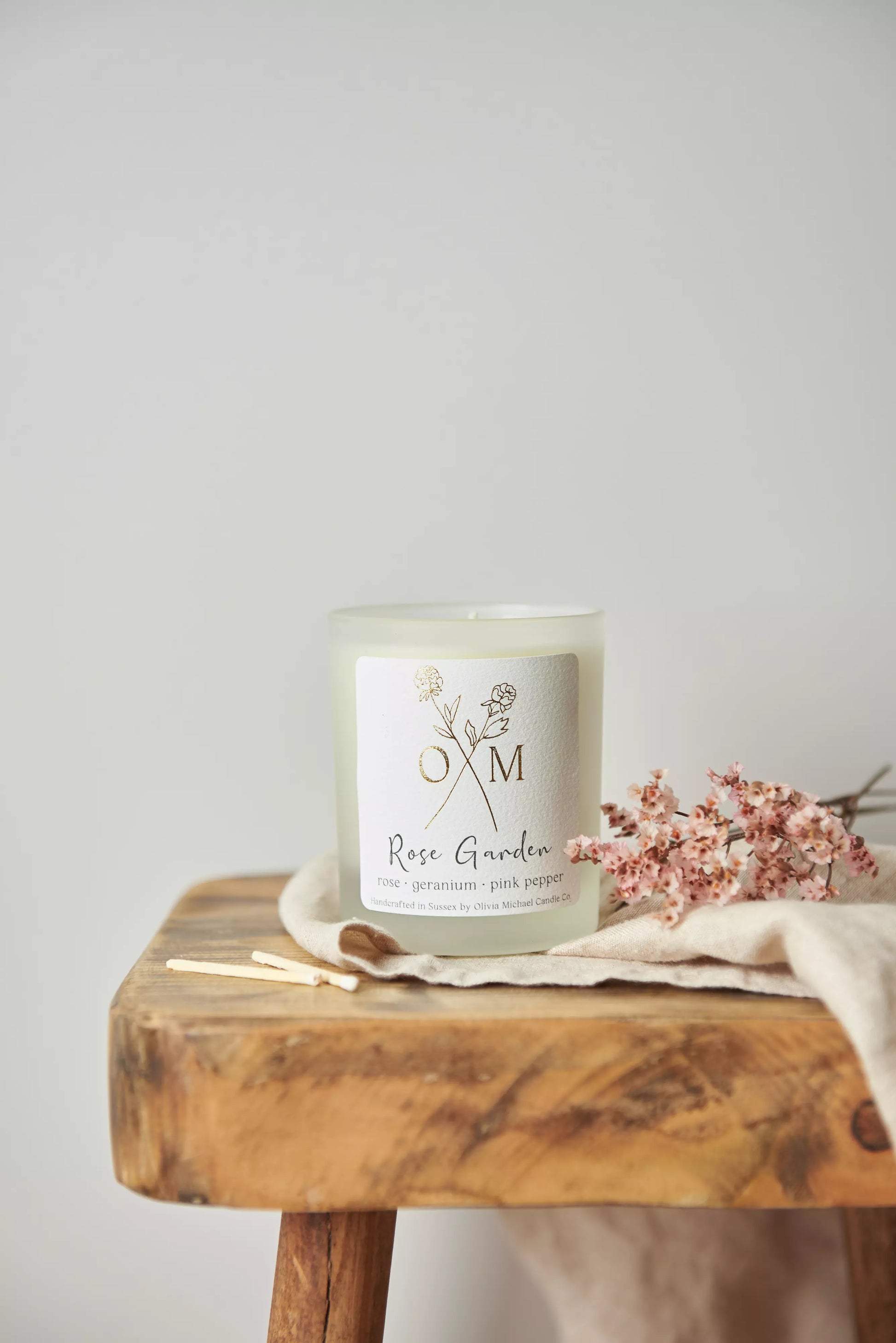 Our rose aromatherapy candle is on display in a clear frosted glass jar.