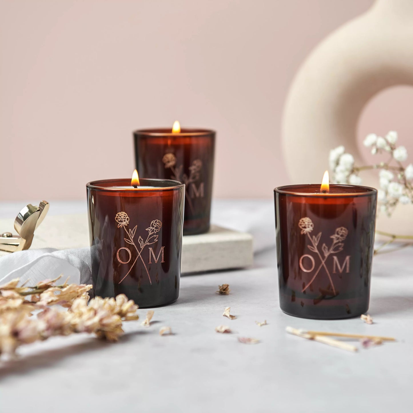 A trio of candles from our Spring Collection candle giftset. The candlelight brightens up the etched logo in the glass.